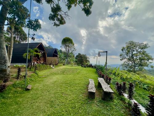 a bench sitting in the grass next to a building at Munduk Harum Glamping in Munduk