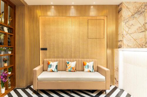 a couch with pillows on it in a room at PINNACLE Udaipur - Boutique Rooftop Pool Hotel, Near the Lakes in Udaipur