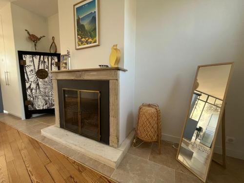 a living room with a fireplace and a mirror at Kaza Blue - Maison familiale Rambouillet centre in Rambouillet