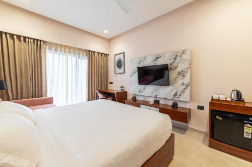 a hotel room with a bed and a television at PINNACLE Udaipur - Boutique Rooftop Pool Hotel, Near the Lakes in Udaipur