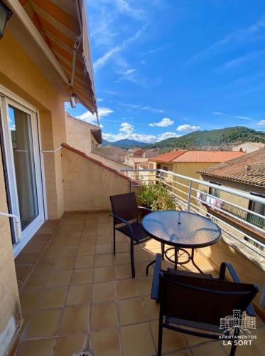 a patio with two tables and chairs on a balcony at La Sort - Castillo in Valderrobres