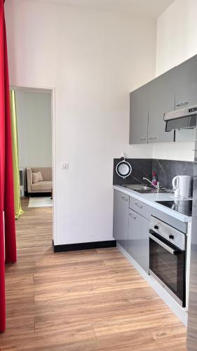 a kitchen with white appliances and a wooden floor at Hôtel de la paix in Limoges