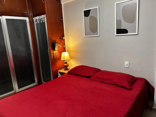 ein Schlafzimmer mit einem roten Bett mit einer roten Decke in der Unterkunft Cavalinho Branco in Águas de Lindóia