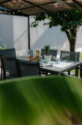 an outdoor table and chairs with a table and a tree at Casa Piero, relax e piscina privata tra le colline delle Langhe in Alba