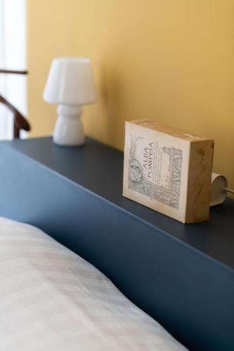 a box sitting on a table next to a bed at Casa Piero, relax e piscina privata tra le colline delle Langhe in Alba