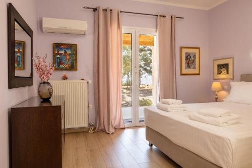 a bedroom with a large bed and a window at Olas y olivos in Akrotiri