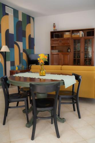 a dining room with a table and chairs and a couch at Casa Piero, relax e piscina privata tra le colline delle Langhe in Alba