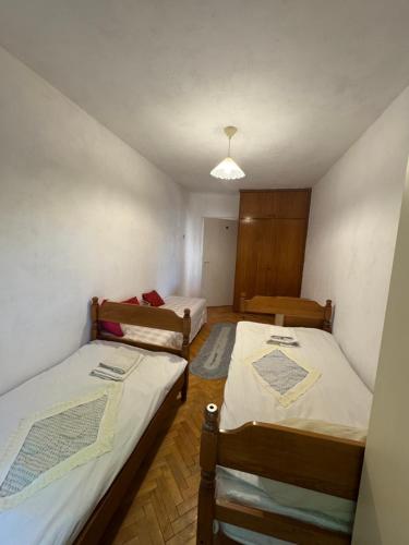 a room with two beds and a lamp in it at Klina Apartment in Skopje
