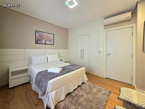 a bedroom with a bed and a door to a room at Apt térreo amplo 2 quartos prox do Paraguai in Foz do Iguaçu