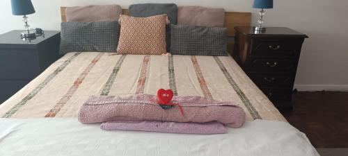 a bed with a blanket and a red heart on it at As Chaves do Cantinho da Paz in Santarém