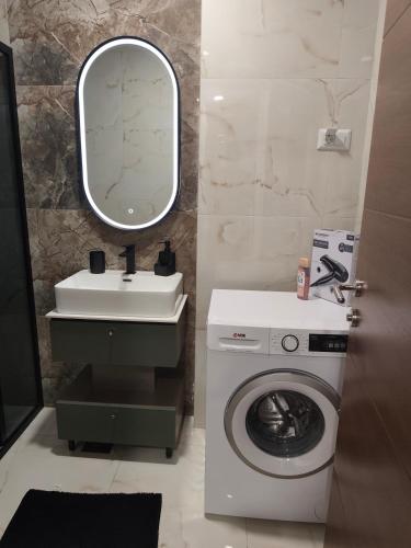 a bathroom with a washing machine and a sink at Sunshine III Apartment in Kragujevac
