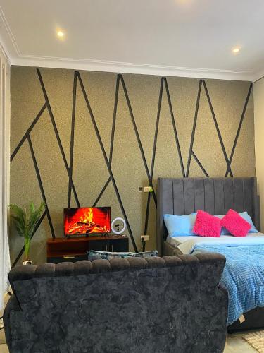 1 dormitorio con cama, sofá y chimenea en Luxury Stay Ug, en Namugongo