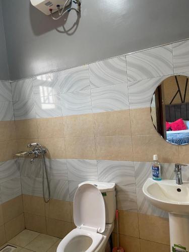 un baño con inodoro y lavabo en Luxury Stay Ug, en Namugongo