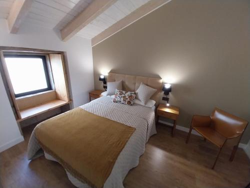 a bedroom with a bed and a window and a chair at Casa Gafura in Barro