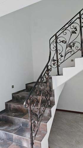 a staircase with wrought iron railings and a white wall at Villa EL&ES in Ciężkowice