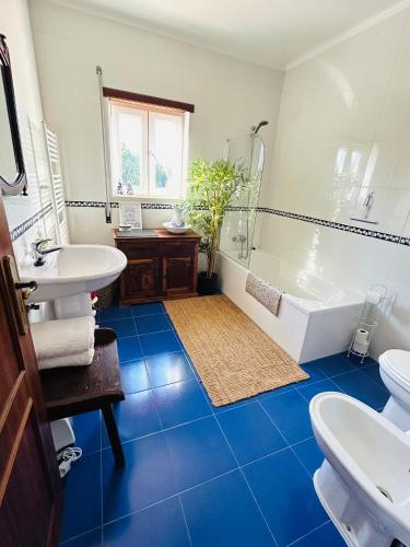 a bathroom with a blue tile floor and a tub and sink at Sunrise Villa Alvorada - Orchard Lookout in São Miguel