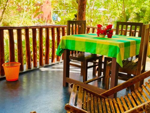 a table with a green and yellow table cloth on a porch at La Casa Safari Resort in Udawalawe