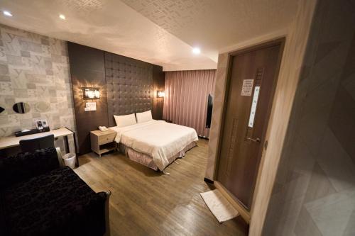 a hotel room with a bed and a couch at The Riverside Hotel Fashion in Kaohsiung