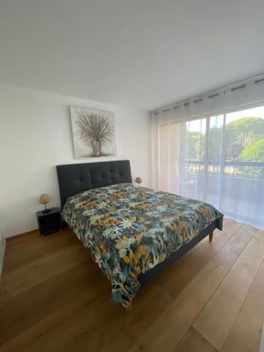 a bedroom with a bed with a floral bedspread at Parc Baie des Anges in Villeneuve-Loubet