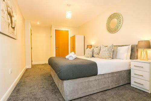 a bedroom with a large bed and a mirror at Cosy Stays in Ashford Large 2 Bedroom Apartment in Kennington