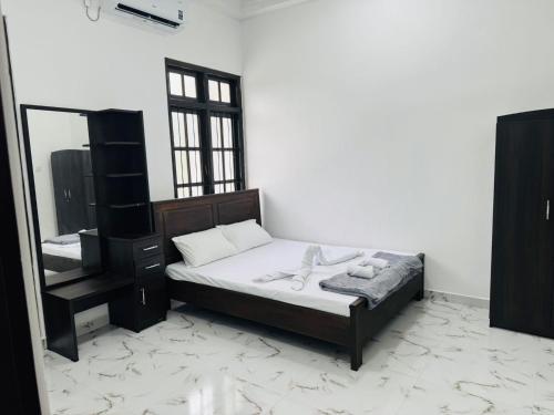 a bedroom with a bed and a dresser and a mirror at DP Aejis in Dehiwala