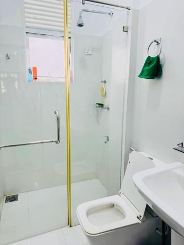 a bathroom with a shower and a toilet and a sink at DP Aejis in Dehiwala