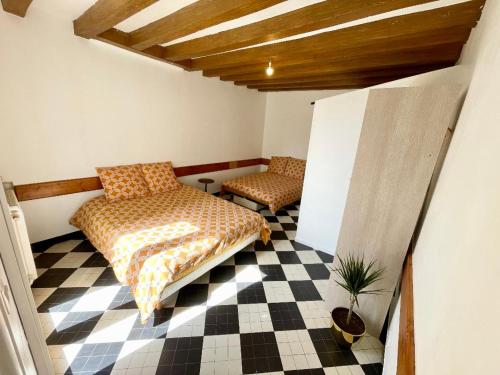 a room with two beds on a checkered floor at Logement proche Zoo de Beauval in Écueillé