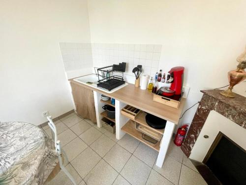 a small kitchen with a desk in a room at Logement proche Zoo de Beauval in Écueillé