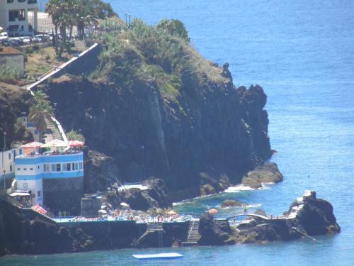 a building on a cliff next to the ocean at Villa Formosa in Funchal