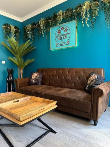 a living room with a brown couch and a blue wall at CHINATOWN DREAM By MIMI in Dole