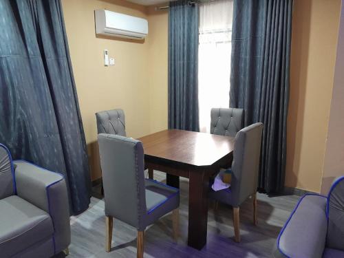 a dining room with a table and chairs and a window at 423 Apartments in Ibadan