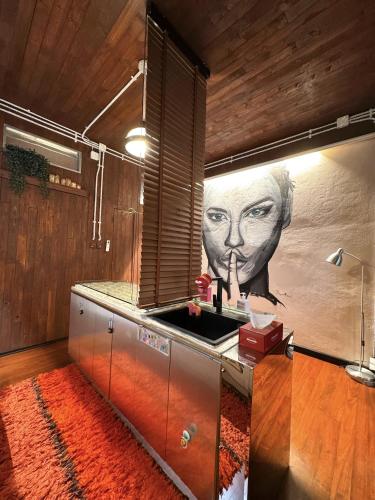 a kitchen with a painting of a face on the wall at New York Loft & Japanese Magic by V4SKIN in Bangkok