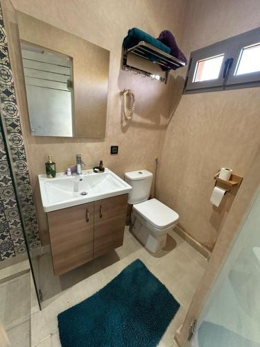 a bathroom with a sink and a toilet and a mirror at Villa Dar Hamza Marrakech in Tahannout