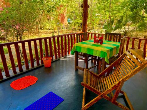 a deck with a table and chairs on a porch at La Casa Safari Resort in Udawalawe