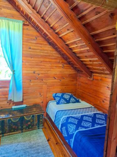 a bedroom with two beds in a log cabin at Vikendica Drinski LAD in Loznica