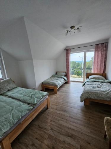 a bedroom with two beds and a large window at Villa EL&ES in Ciężkowice