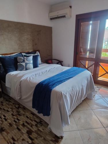 a bedroom with a large bed with blue pillows at Sobrado 4 km do Shopping Iguatemi, Parque Germânia e Hosp Conceição in Porto Alegre
