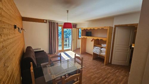 un soggiorno con un divano e un tavolo di vetro di Orelle 3 Vallées - Studio 4 personnes a Orelle