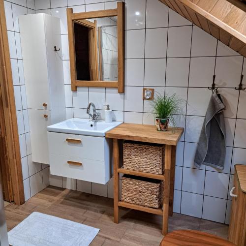 ein Badezimmer mit Waschbecken und Spiegel in der Unterkunft Ciurkówka in Sieniawa