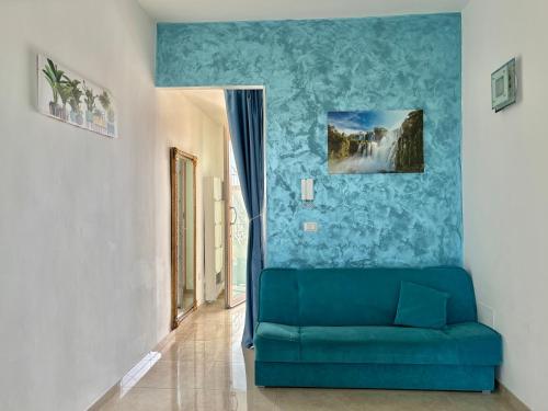 a blue couch in a room with a blue wall at Il Mare in Tasca - Casa Vacanze - loc.Torre Lapillo (LE) - Salento in Torre Lapillo