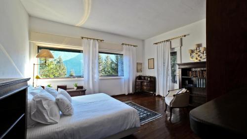 a bedroom with a bed and a large window at Villa Virginia Calalzo di Cadore in Calalzo