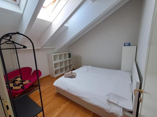 a bedroom with a white bed and a red chair at Royal Suite l'attico nel cuore di Varese in Varese