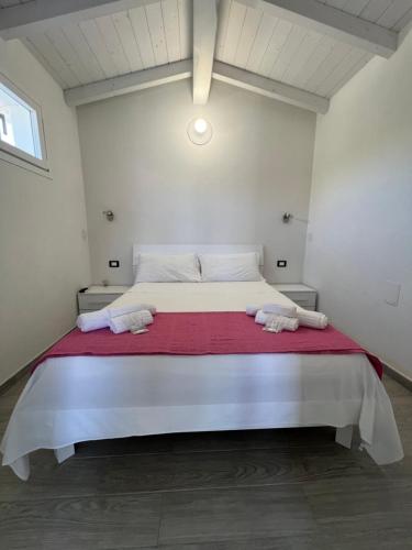 a bedroom with a large bed with two towels on it at Almà in Torre delle Stelle