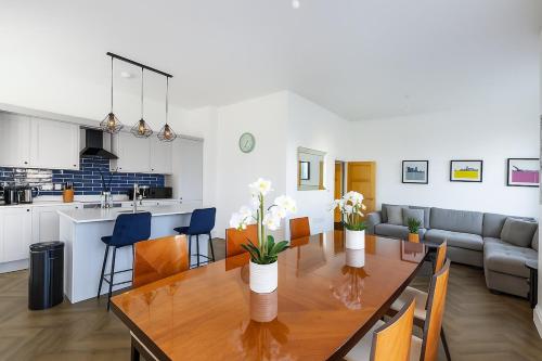 a kitchen and a dining room with a table with flowers at Northampton 3 Bed 3 Bathroom New Duplex Apartment in Spinney Hill