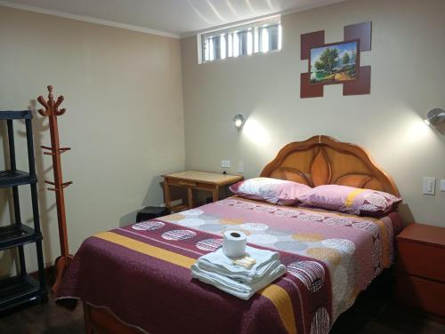 a bedroom with a bed with a cup on it at Casa del Virrey Hospedaje in Jauja