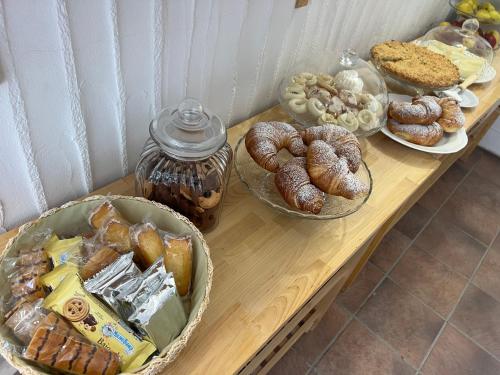 a table filled with different types of bread and pastries at Almà in Torre delle Stelle