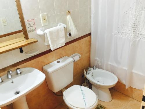 uma casa de banho com um WC branco e um lavatório. em Apart Hotel TY Coed em Puerto Madryn