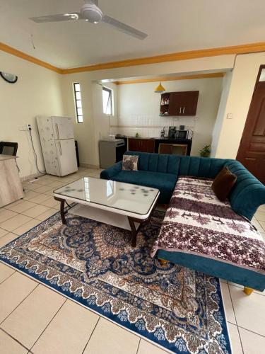 a living room with a blue couch and a coffee table at New 2Bedroom apartment with Swimming Pool in Mtwapa