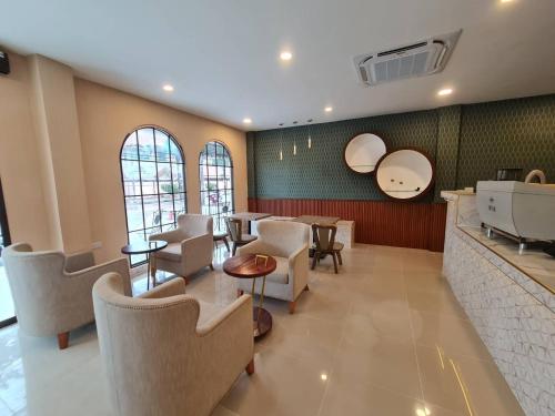 a waiting room with chairs and tables and windows at S-room Scentral Hatyai in Hat Yai