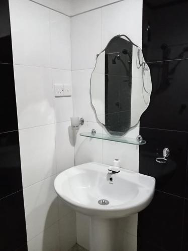 a bathroom with a white sink and a mirror at Ella Compass in Ella